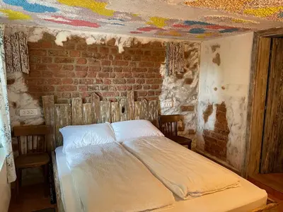 a bed in a room with a brick wall at Vamiš Apartment in Stanjevci