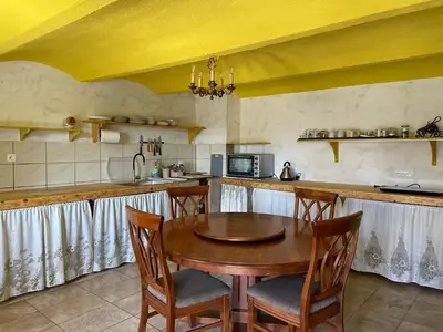 a kitchen with a wooden table and some chairs at Vamiš Apartment in Stanjevci