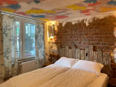 a bedroom with a bed and a brick wall at Vamiš Apartment in Stanjevci