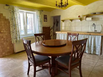 a kitchen with a wooden table and four chairs at Vamiš Apartment in Stanjevci