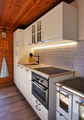 a kitchen with white cabinets and a stove top oven at Chalet Slavko in Bohinjska Bistrica