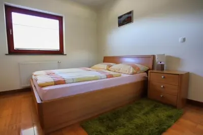 a bedroom with a bed and a dresser and a window at Apartment Harper in Bohinj