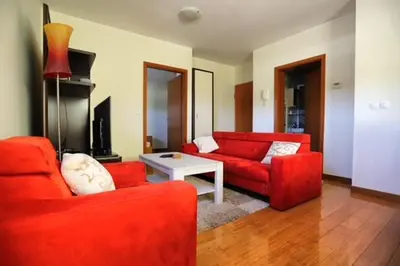 a living room with two red couches and a table at Apartment Harper in Bohinj