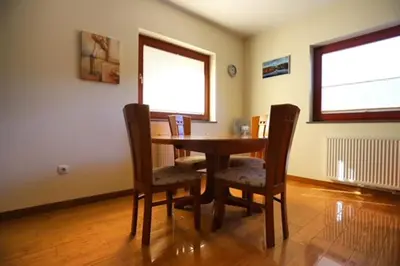 a dining room with a wooden table and chairs at Apartment Harper in Bohinj