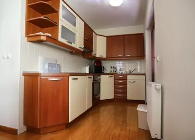 a kitchen with wooden cabinets and a white refrigerator at Apartment Harper in Bohinj
