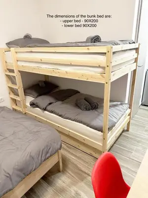 a wooden bunk bed in a room with a red chair at Vesna Studios in Ljubljana