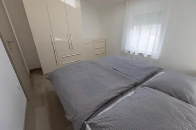 a bedroom with a bed and a white cabinet at Villa Andrea Apartments - Ljubljana in Ljubljana