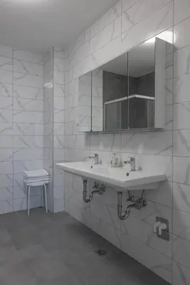 a white bathroom with a sink and a mirror at Villa Andrea Apartments - Ljubljana in Ljubljana