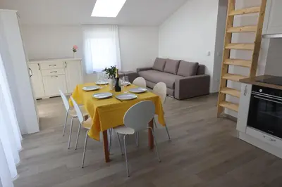 a dining room with a yellow table and chairs at Villa Andrea Apartments - Ljubljana in Ljubljana
