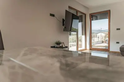 a living room with a flat screen tv and a large window at Villa Brje with Seasonal Pool in Dobravlje