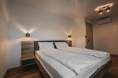 a bedroom with a large bed with white sheets at Villa Brje with Seasonal Pool in Dobravlje