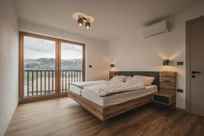 a bedroom with a bed and a large window at Villa Brje with Seasonal Pool in Dobravlje