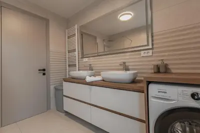 a bathroom with two sinks and a washing machine at Villa Brje with Seasonal Pool in Dobravlje