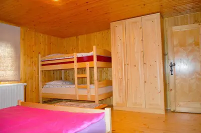 a bedroom with two bunk beds and a door at Brunarica Petric - Bela krajina - Komarna vas - Smučišče Gače - Semič in Komarna Vas
