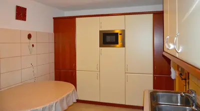 a kitchen with white cabinets and a microwave at Brunarica Petric - Bela krajina - Komarna vas - Smučišče Gače - Semič in Komarna Vas