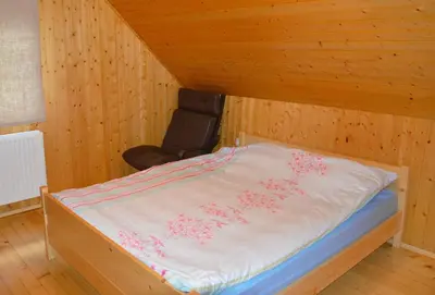a bed with pink flowers on it in a room at Brunarica Petric - Bela krajina - Komarna vas - Smučišče Gače - Semič in Komarna Vas