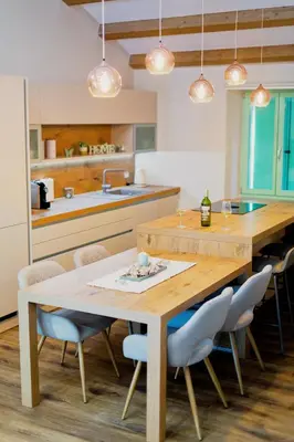 a kitchen with a wooden table and chairs at Hiša Skala Kubed in Gračišče