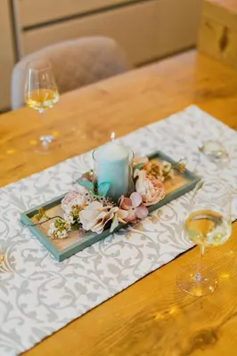 a candle on a plate with flowers on a table at Hiša Skala Kubed in Gračišče