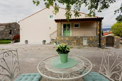 a table and chairs in front of a house at Hiša Skala Kubed in Gračišče