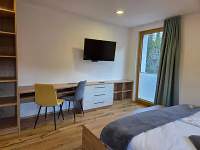 a bedroom with a desk with a television and a bed at Vila Natalia in Kranjska Gora