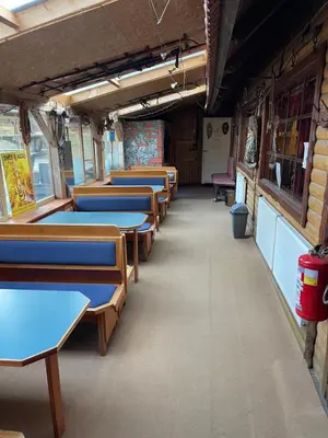a row of tables and chairs in a train car at Chalet on Pohorje hill Maribor bike park next to the downhill track in Pohorje