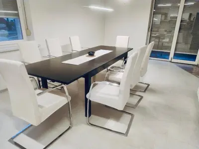 a conference room with a black table and white chairs at Bella Vita in Postojna