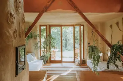 a living room with a couch and some plants at Private Eco Cottage in Nature in Šulinci