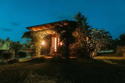 a small house with a light on the side of it at Private Eco Cottage in Nature in Šulinci