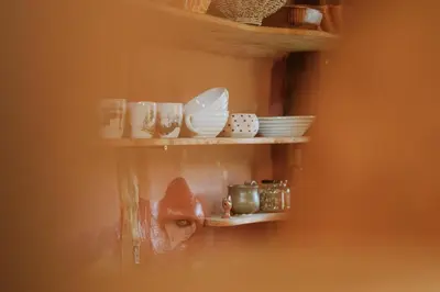a shelf with plates and dishes on it at Private Eco Cottage in Nature in Šulinci