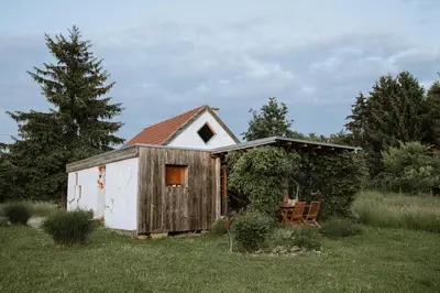 a small shed with a table and chairs in a field at Private Eco Cottage in Nature in Šulinci