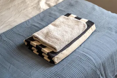 a pile of towels sitting on top of a bed at Central Castle View Apartment in Ljubljana
