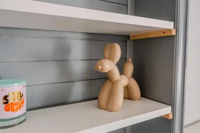two wooden dolls sitting on a shelf in a drawer at Central Castle View Apartment in Ljubljana