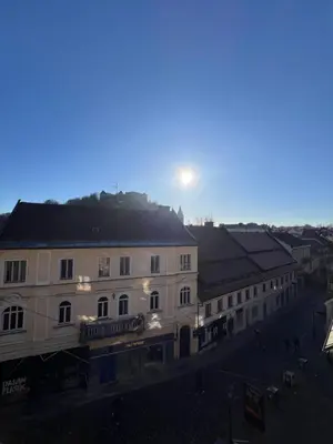 a view of a building with the sun behind it at Central Castle View Apartment in Ljubljana