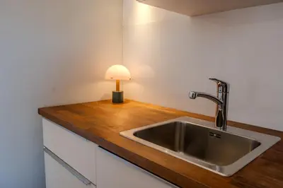 a kitchen sink with a lamp on a wooden counter at Central Castle View Apartment in Ljubljana