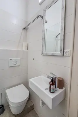 a white bathroom with a toilet and a sink at Central Castle View Apartment in Ljubljana