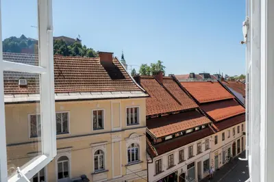 a view of roofs of buildings from a window at Central Castle View Apartment in Ljubljana