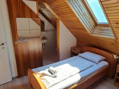 a bedroom with a bed in a wooden room at Hiša Bistrica in Bohinj