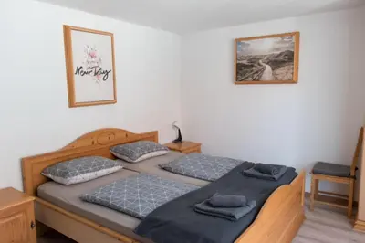a bedroom with two beds and a picture on the wall at Hiša Bistrica in Bohinj