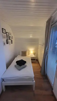 a white bed in a small room with a window at Apartma Leila in Bohinj