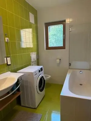 a bathroom with a sink and a washing machine at BOLFI LUX Apartma z balkonom in Pohorje
