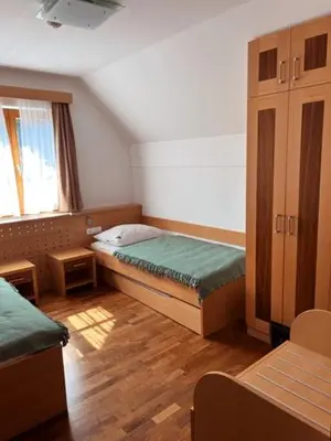 a small room with two beds and a window at BOLFI LUX Apartma z balkonom in Pohorje