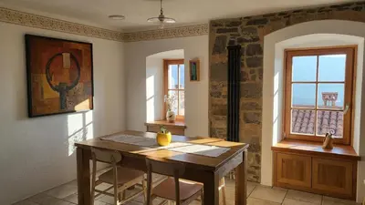 a dining room with a wooden table and a window at Hiša Manira in Ajdovščina