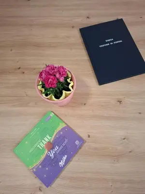 a table with a bowl of pink flowers and books at Spa Cottage the Moon house Terme Čatež in Čatež ob Savi