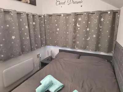 a bedroom with a bed and stars curtains at Spa Cottage the Moon house Terme Čatež in Čatež ob Savi