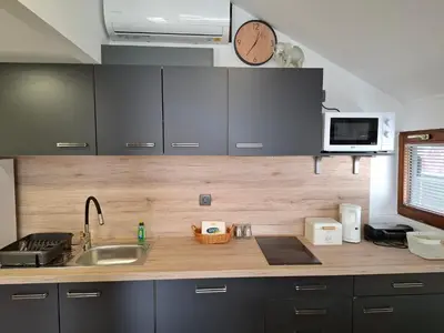 a kitchen with a sink and a clock on the wall at Spa Cottage the Moon house Terme Čatež in Čatež ob Savi