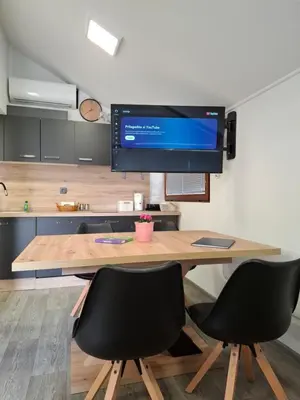a kitchen with a table with two chairs and a tv at Spa Cottage the Moon house Terme Čatež in Čatež ob Savi