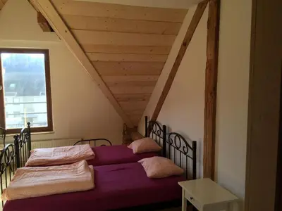a bedroom with a bed with purple sheets and a window at Hiša 1907 in Bled