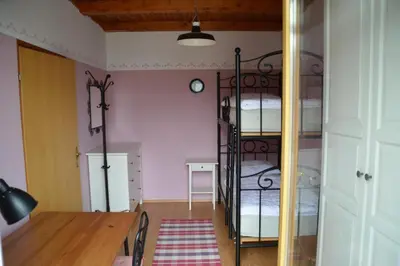 a room with two bunk beds and a table at Hiša 1907 in Bled