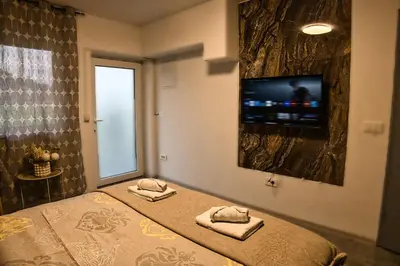 a bedroom with a bed and a tv on the wall at Lux room & ljubljana in Ljubljana