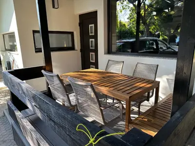 a wooden table and chairs on a patio at Family Holiday Home in Terme Čatež in Čatež ob Savi